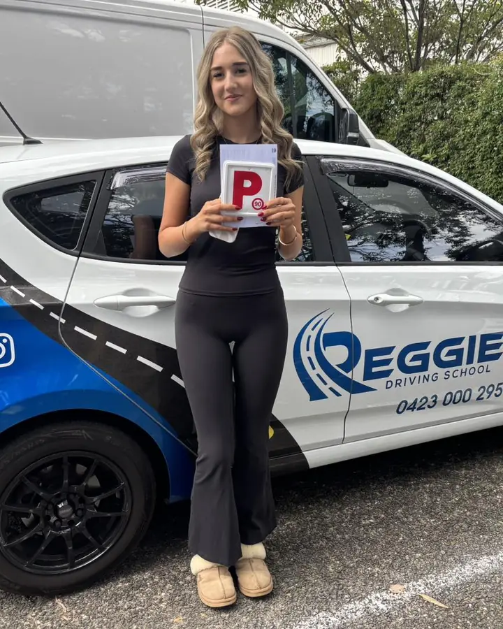 A student with her P plate beside Reggie's car
